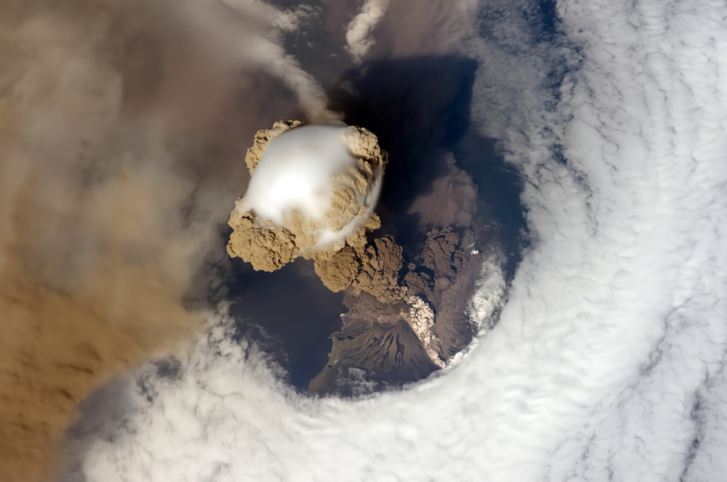 Vista satelital de una erupción volcánica con una gran nube de ceniza, tomada desde el espacio por la NASA