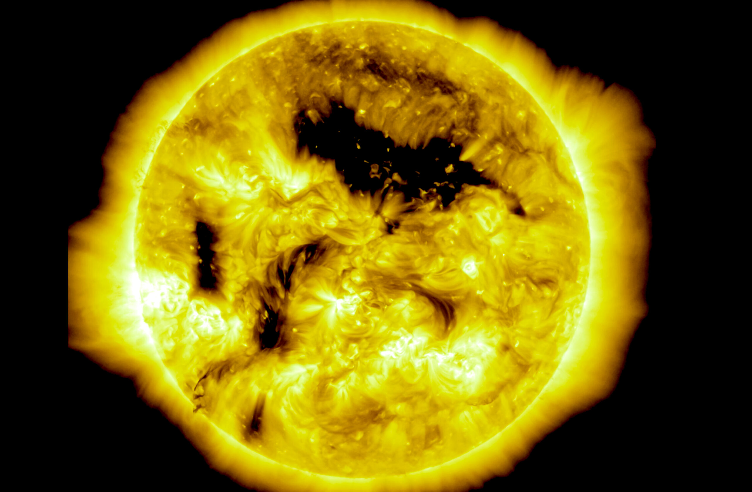 Imagen del Sol con remolinos de plasma y manchas oscuras llamadas agujeros coronales