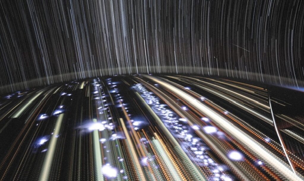 Fotografía de larga exposición desde la Crew Dragon mostrando star trails y luces de la Tierra desde la órbita